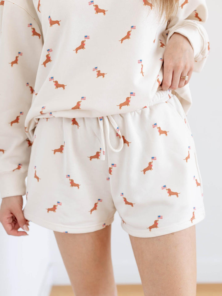 White pajama set with dog pattern worn by a person on a white background
