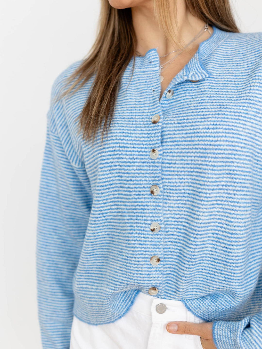Blue striped sweater worn by a person on a white background