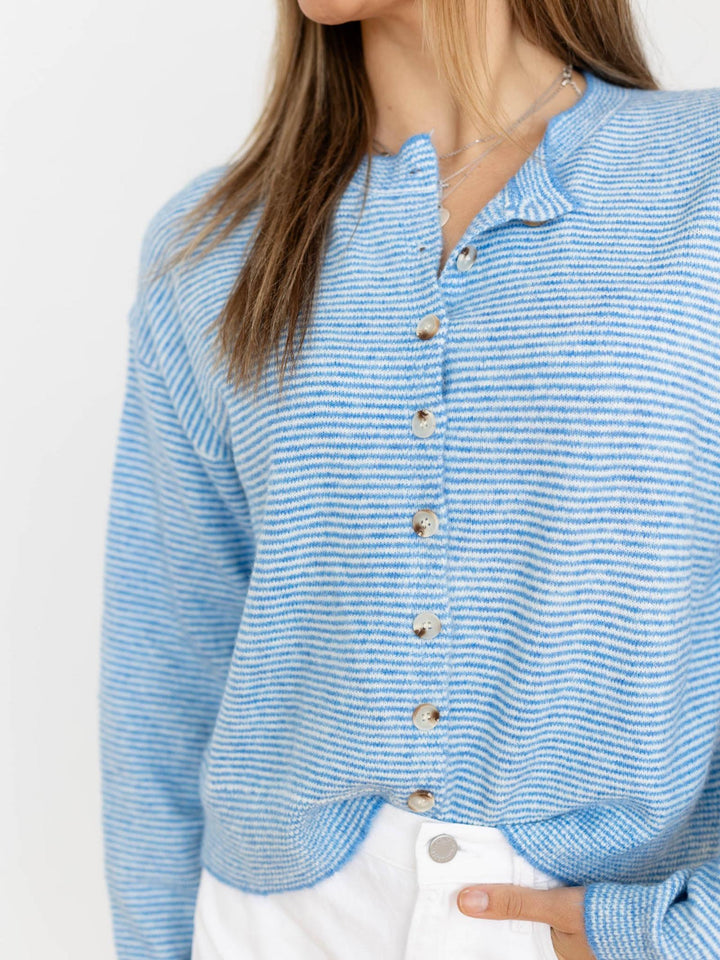 Blue striped sweater worn by a person on a white background