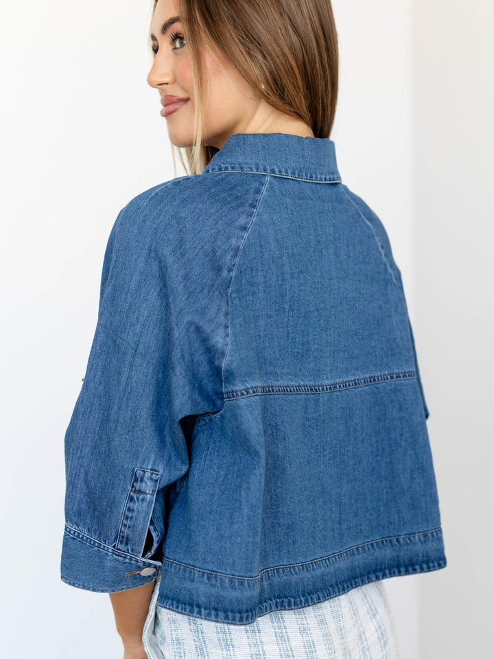 Woman wearing a blue denim jacket on a white background