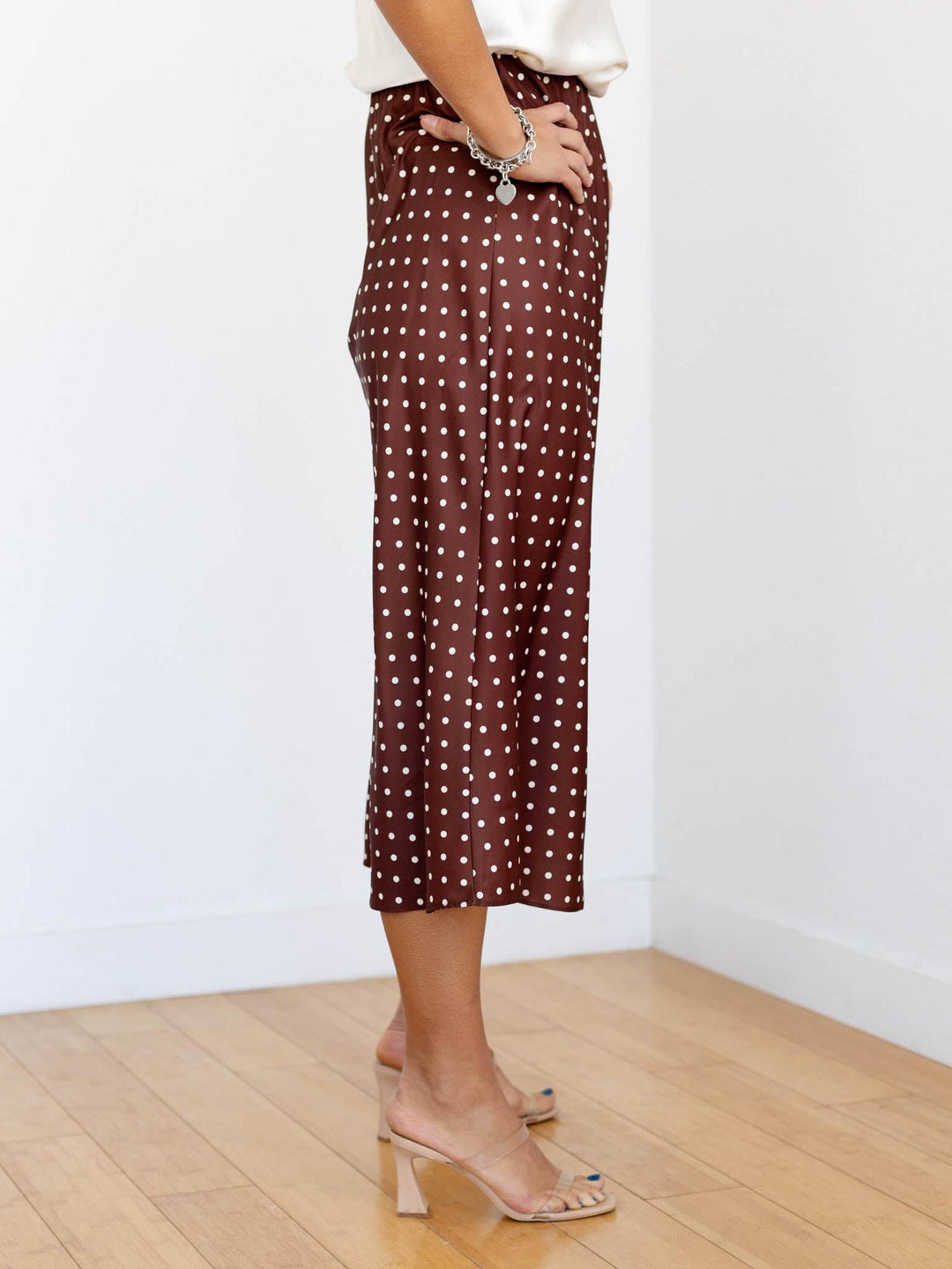Person wearing a brown polka dot skirt on a white background