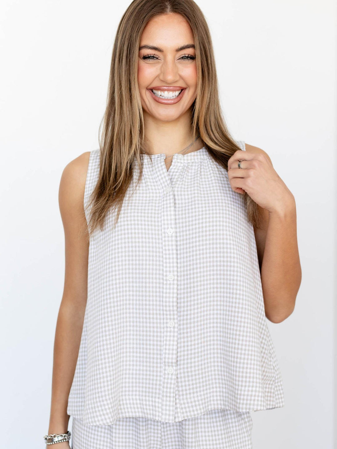 Woman wearing a sleeveless checkered top on a white background