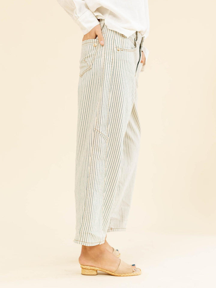 Person wearing light-colored striped pants on a beige background