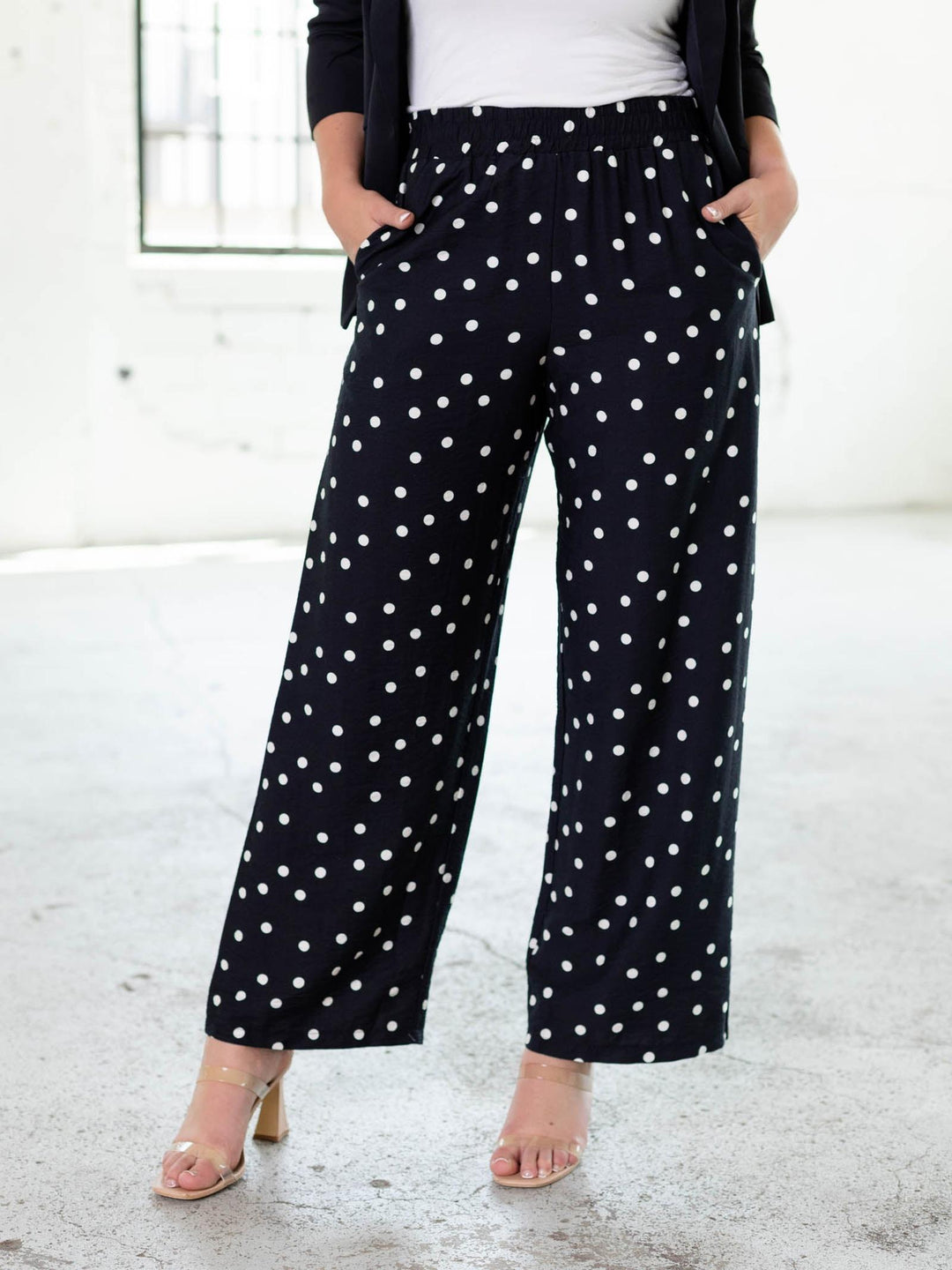 Navy and white polka dot wide-leg pants with an elastic waistband and woven side pockets.