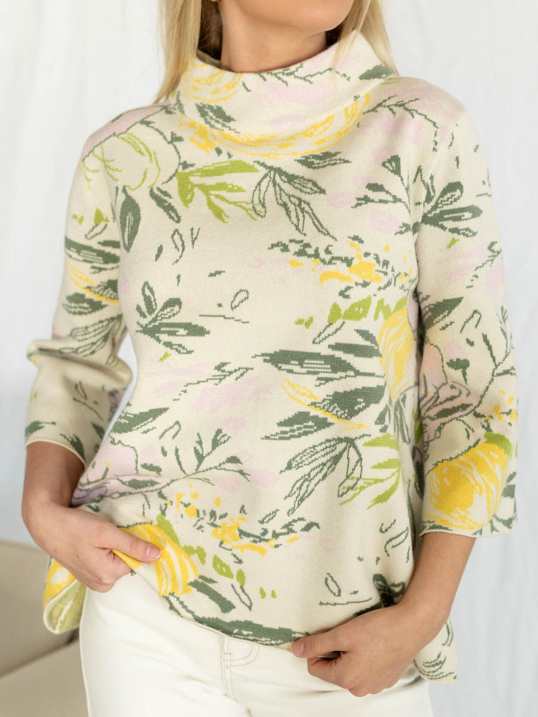 Woman wearing a floral patterned sweater with a plain background