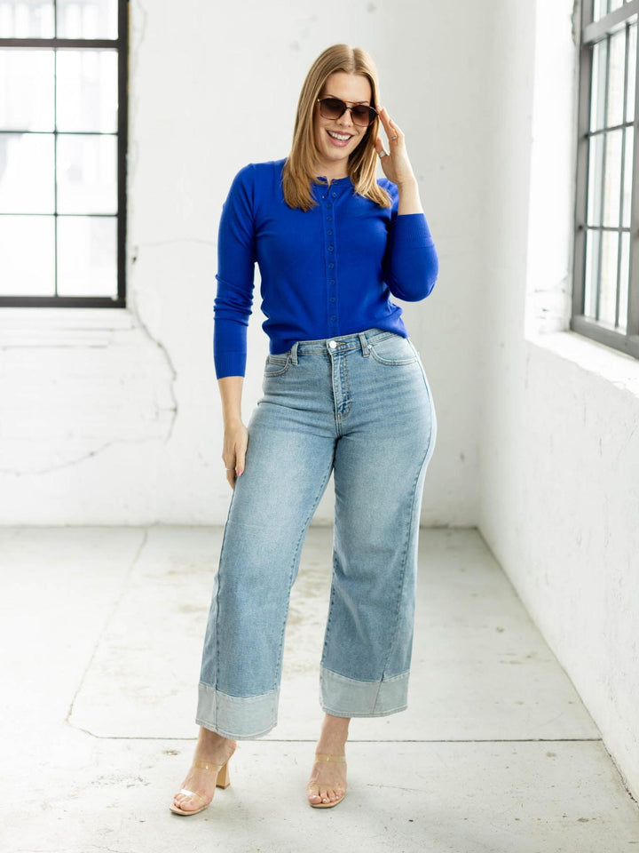 Woman wearing a blue sweater and jeans against a plain background