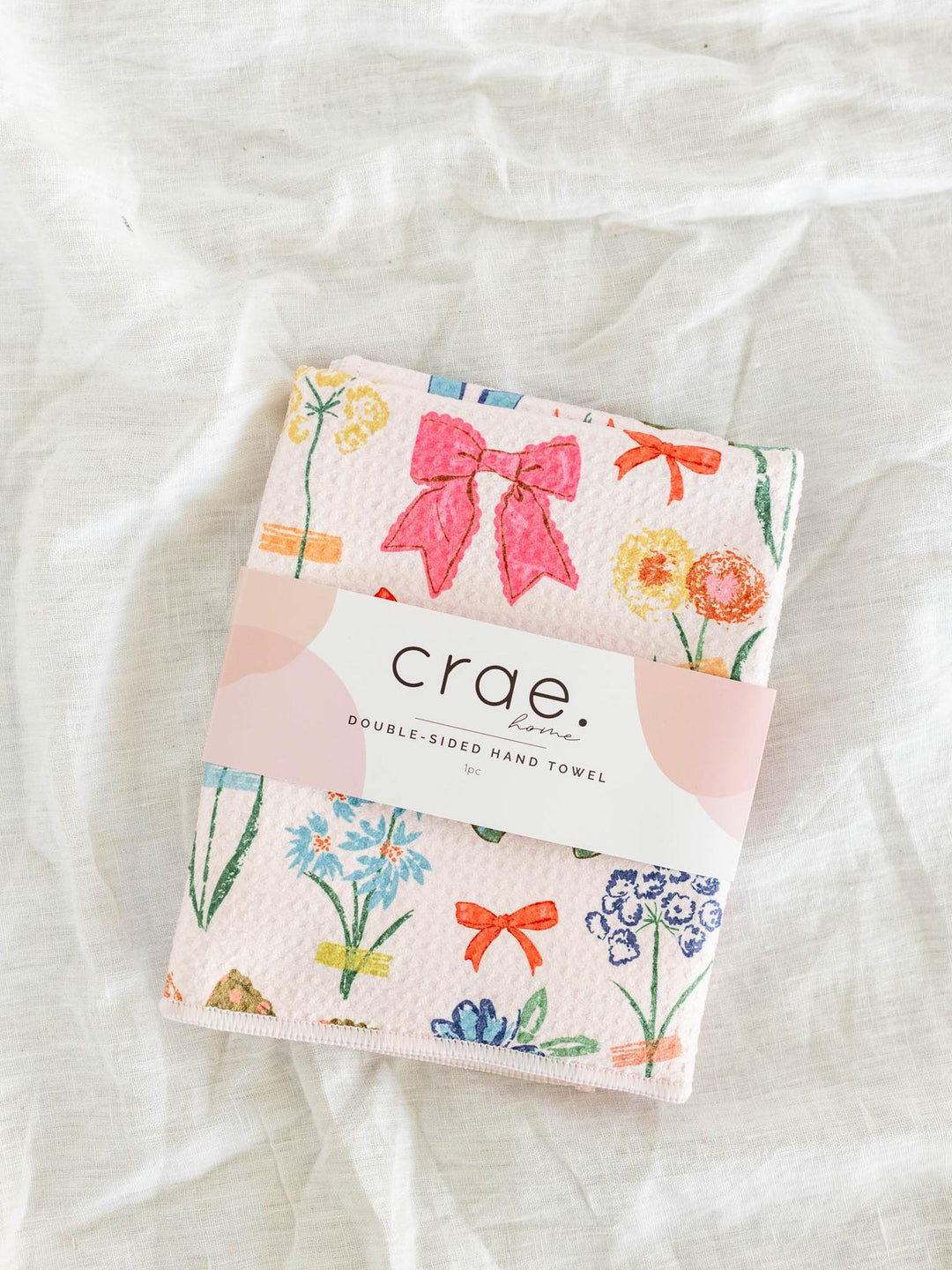 Double-sided hand towel with floral and bow design on a white background