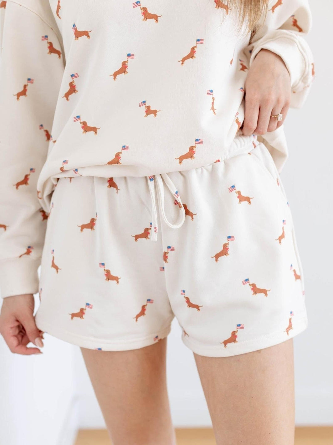 White pajama set with dog pattern worn by a person on a white background