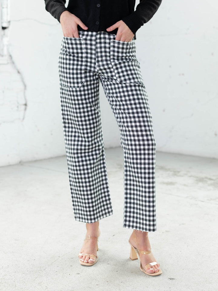 Person wearing black and white checkered pants on a white background