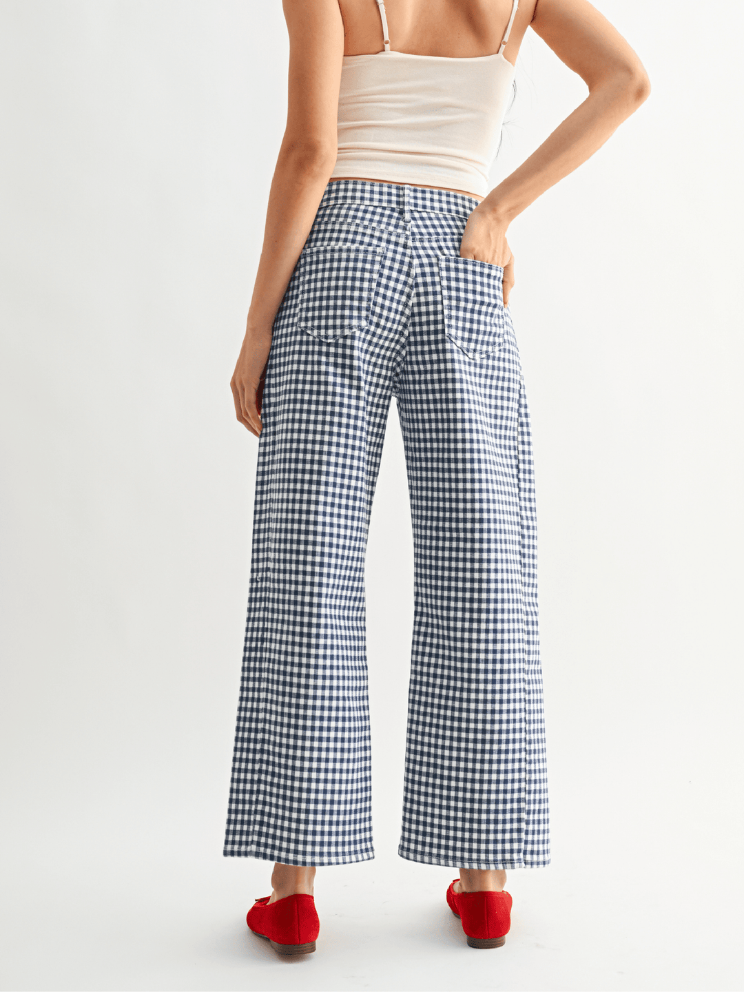 Person wearing blue and white checkered pants on a white background