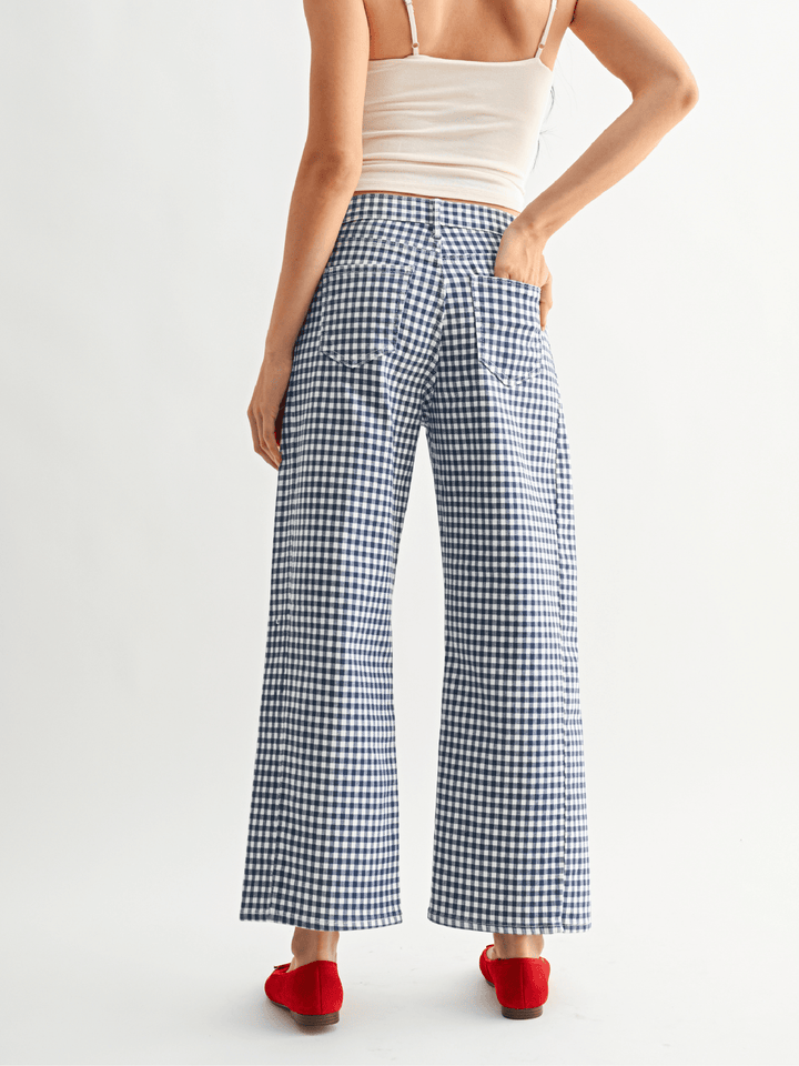 Person wearing blue and white checkered pants on a white background