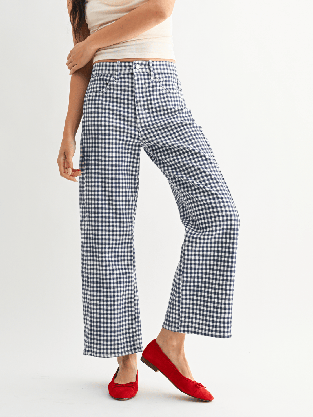 Person wearing blue and white checkered pants with a plain background
