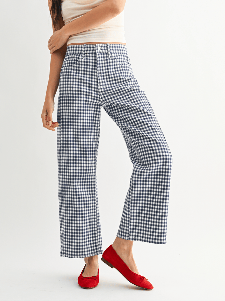 Person wearing blue and white checkered pants with a plain background