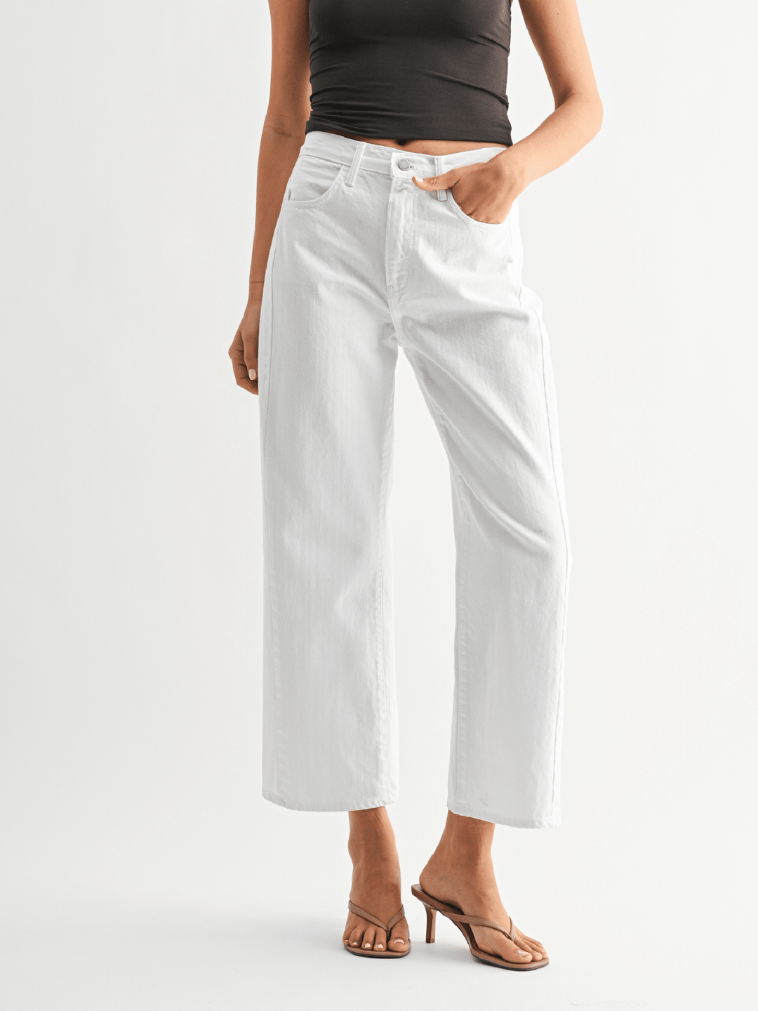 Person wearing white pants on a plain background