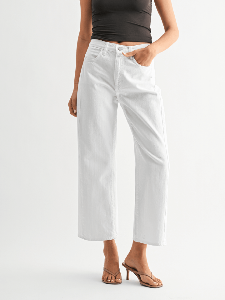 Person wearing white pants on a plain background