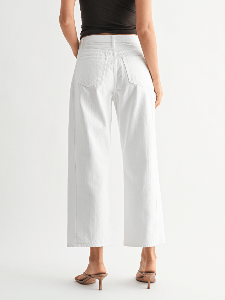 Person wearing white wide-leg pants on a white background