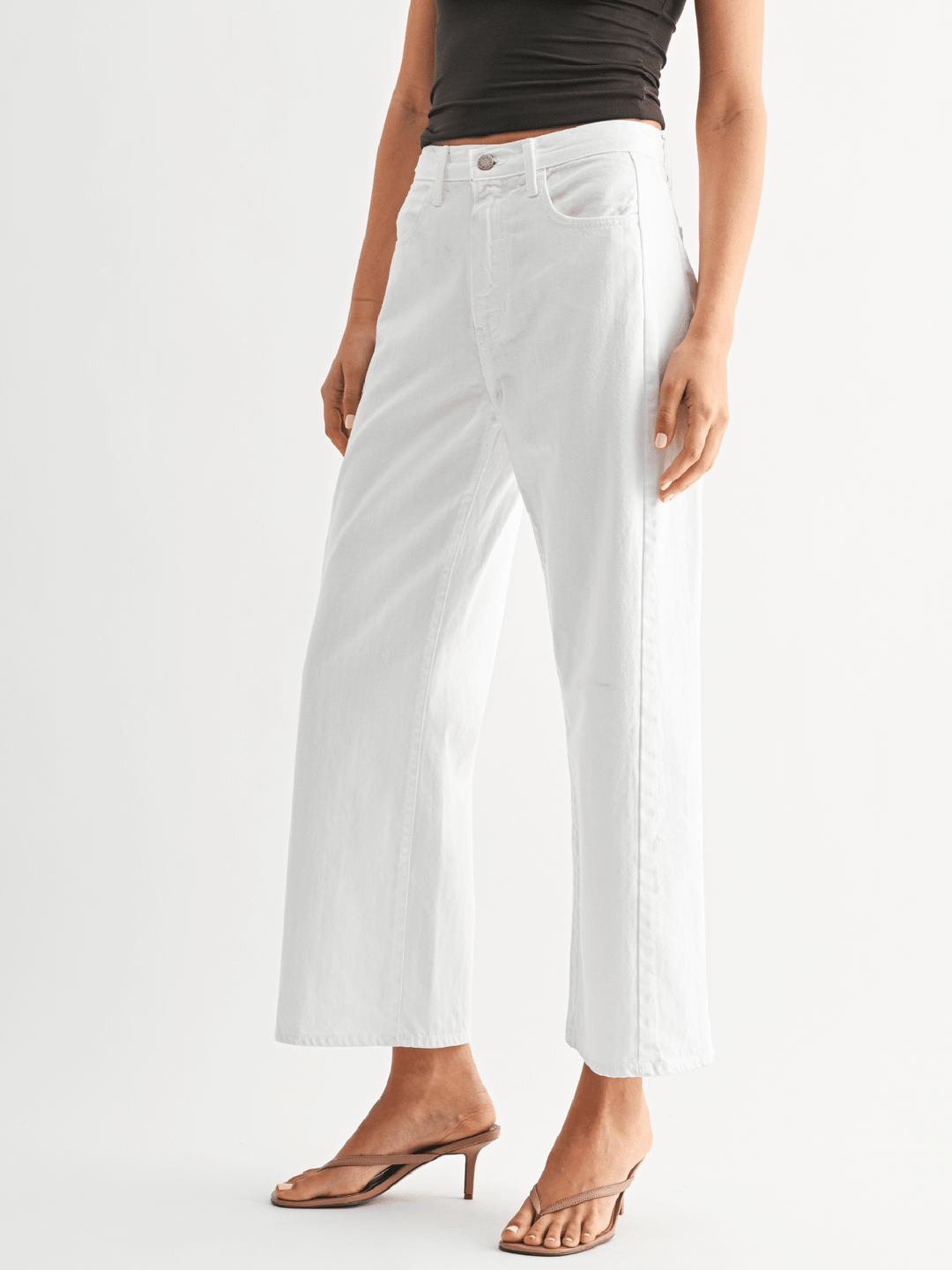 Person wearing white pants on a plain background
