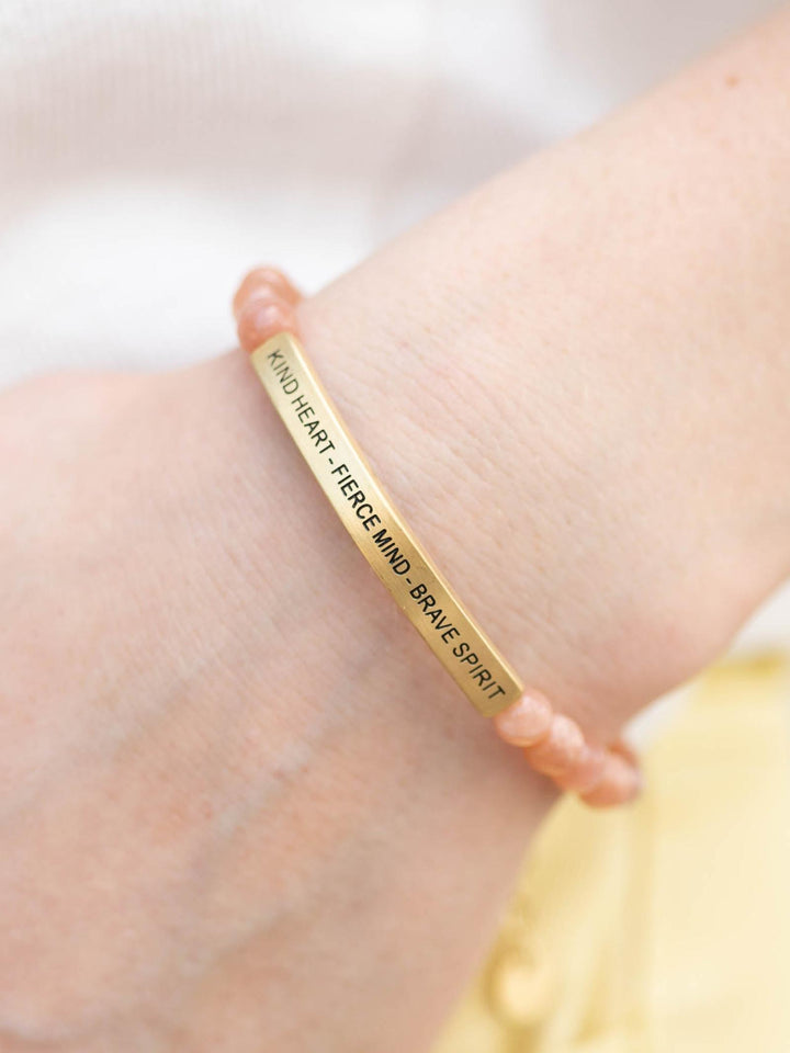 Elevated stone bracelet with warm Sunstone beads and a gold bar engraved with "Kind Heart - Fierce Mind - Brave Spirit".