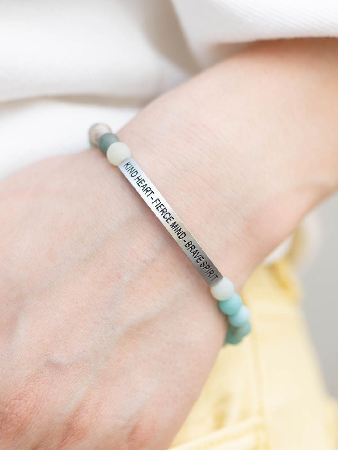 Amazonite stone bracelet with "Kind Heart, Fierce Mind, Brave Spirit" engraved on a silver bar.