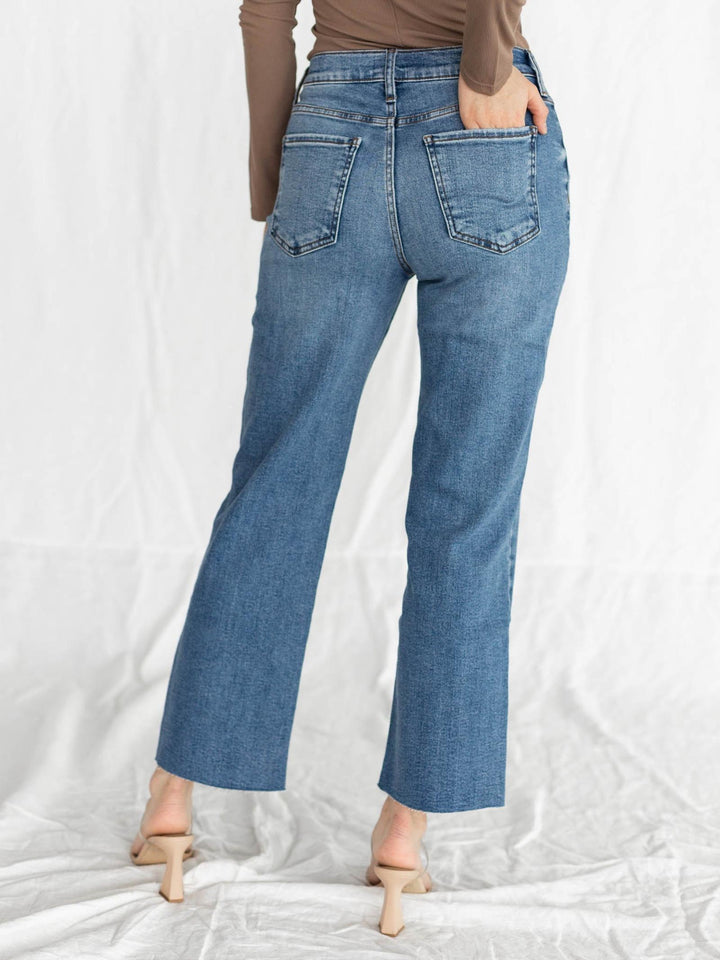 Blue jeans worn by a person on a white background