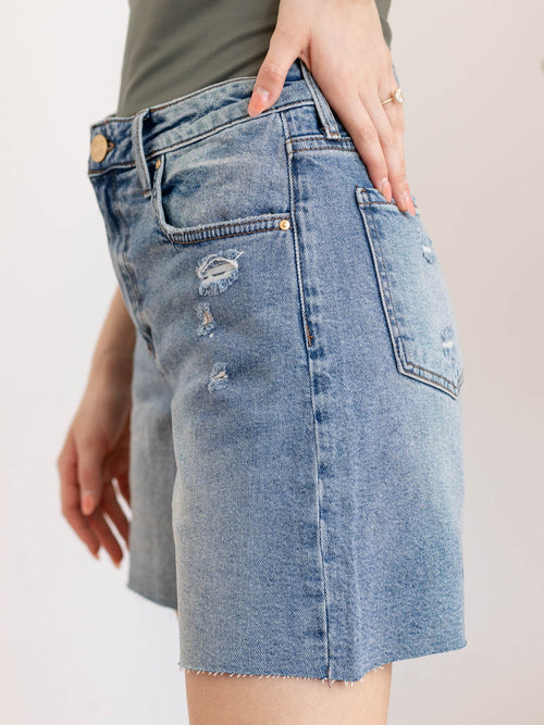 medium wash long inseam raw hem shorts