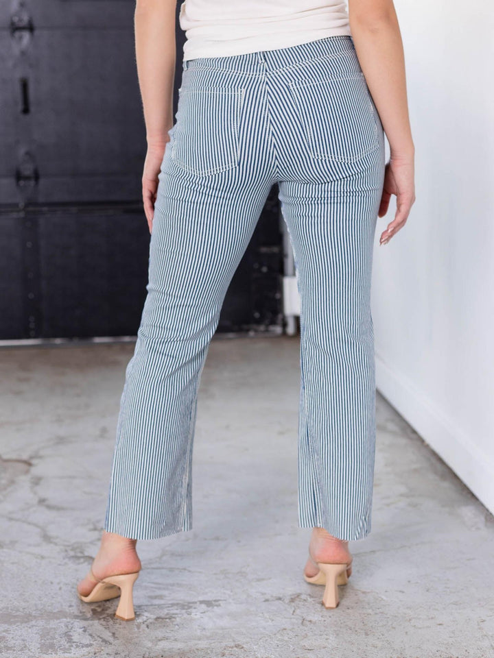 Woman from behind wearing KUT Navy/Ivory Kelsey High Rise Fab Ab striped denim jeans and nude heels.