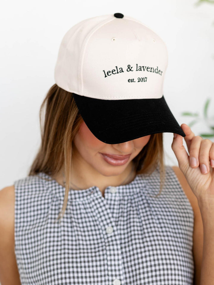 Woman wearing a white and black cap with &