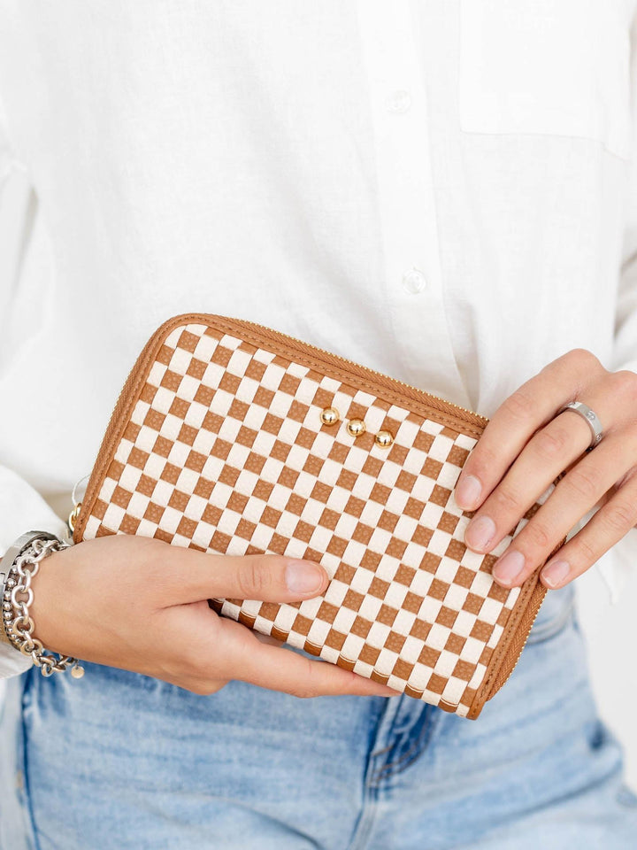Person holding a checkered wallet with a plain background