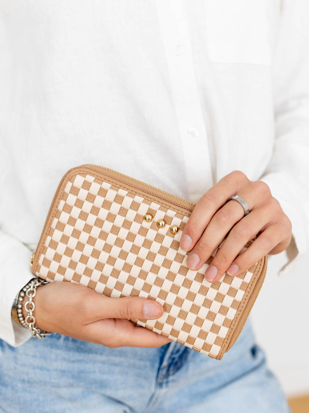 Person holding a checkered wallet with a plain background