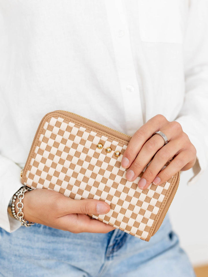 Person holding a checkered wallet with a plain background