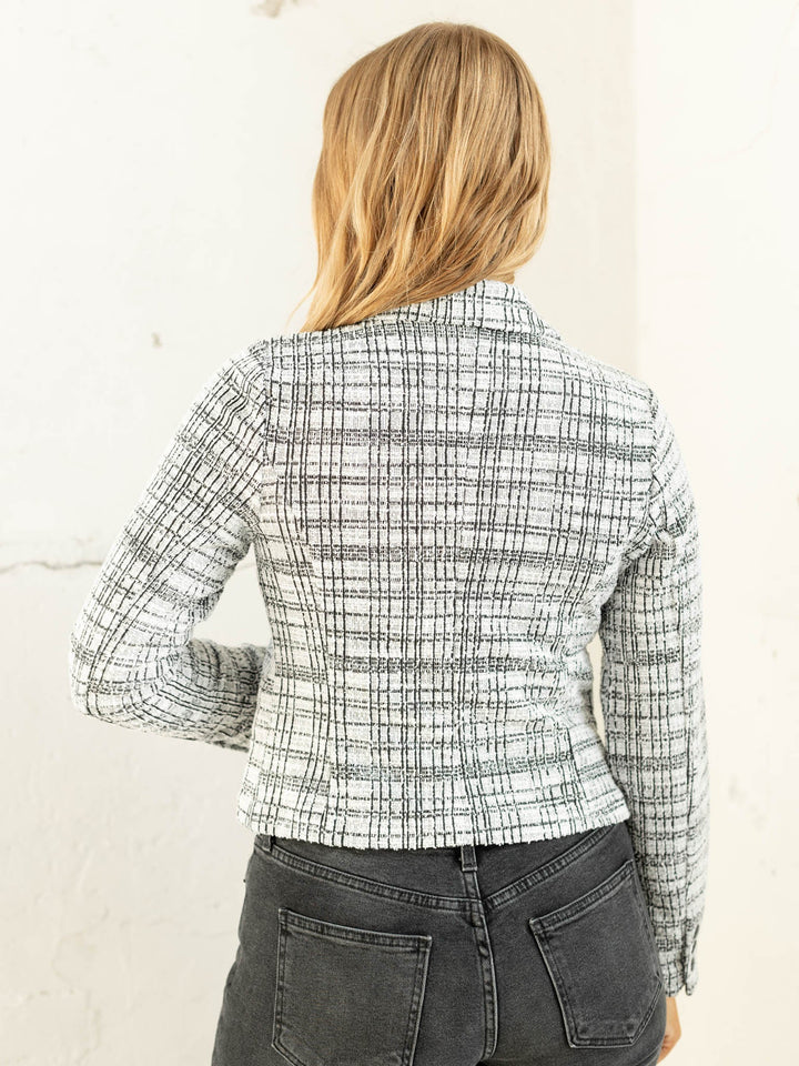 Person wearing a plaid shirt with a white background