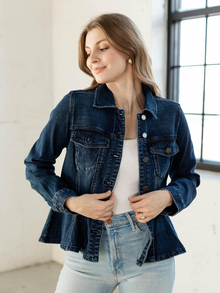 Woman wearing a denim jacket and light blue jeans indoors.