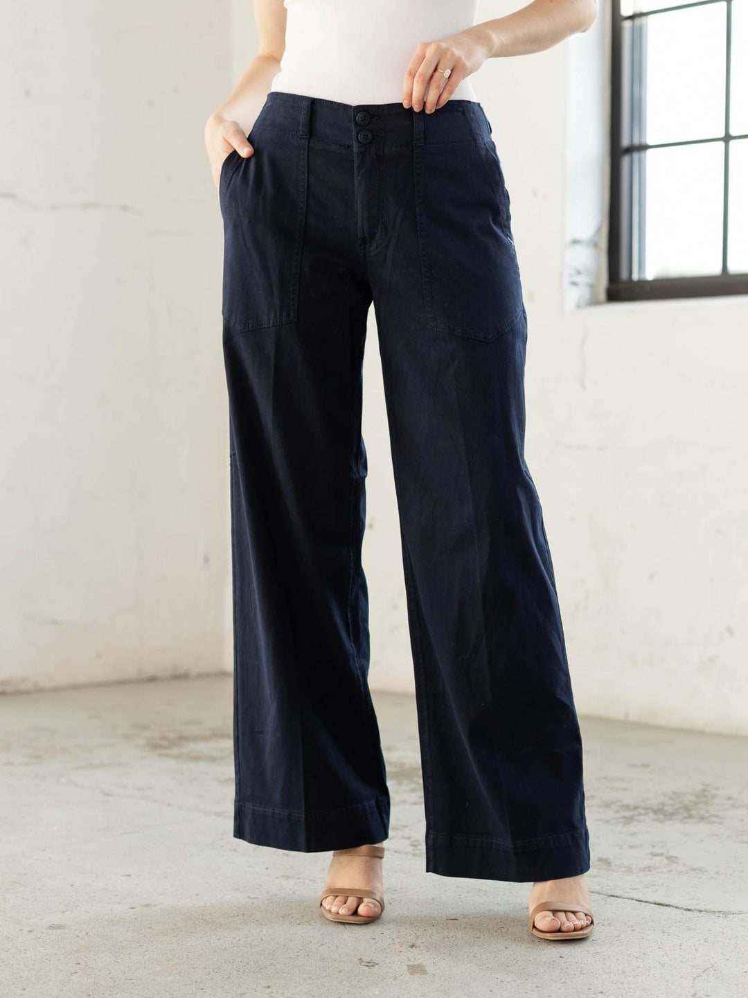 Person wearing navy wide-leg pants in a minimal indoor setting