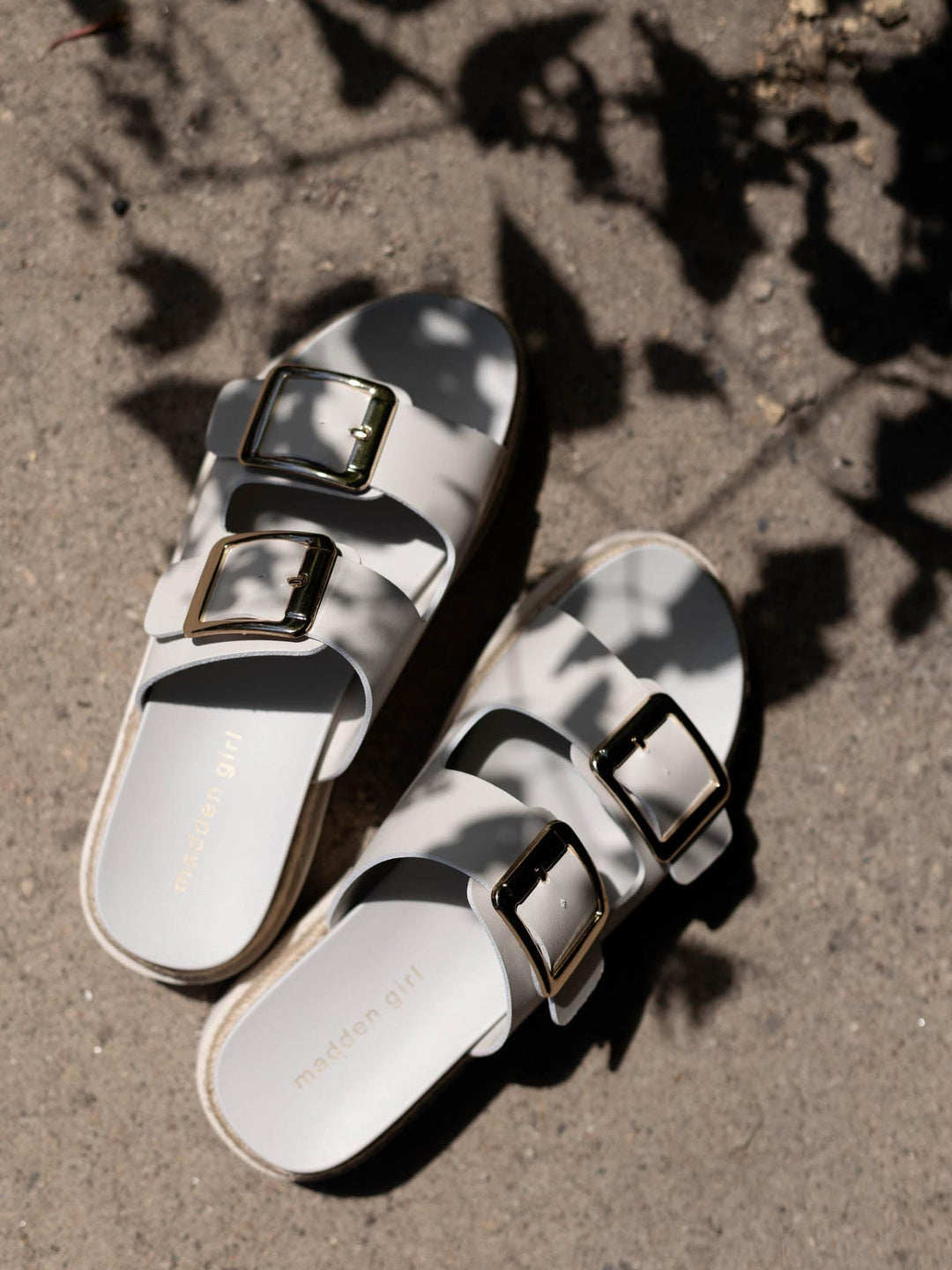 Madden Girl Mythical white faux leather 2 buckle flatbed sandals with gold hardware and espadrille-style platform.