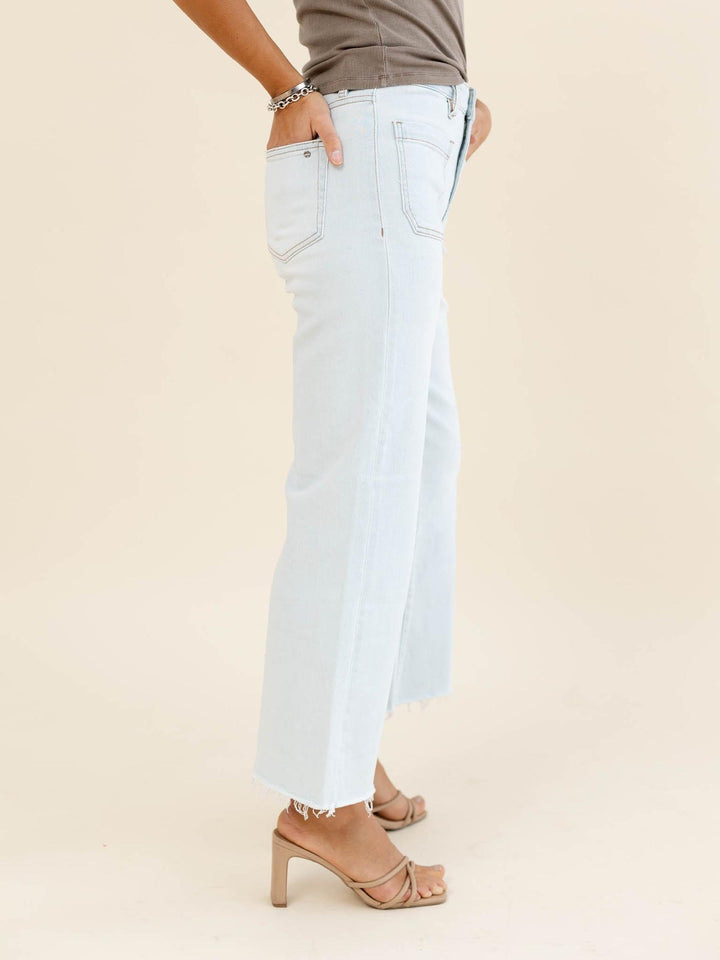 Light blue jeans worn by a person on a beige background