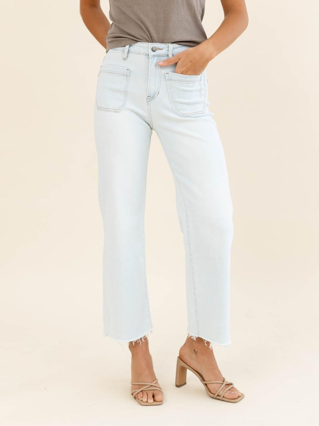 Light blue jeans worn by a person on a beige background