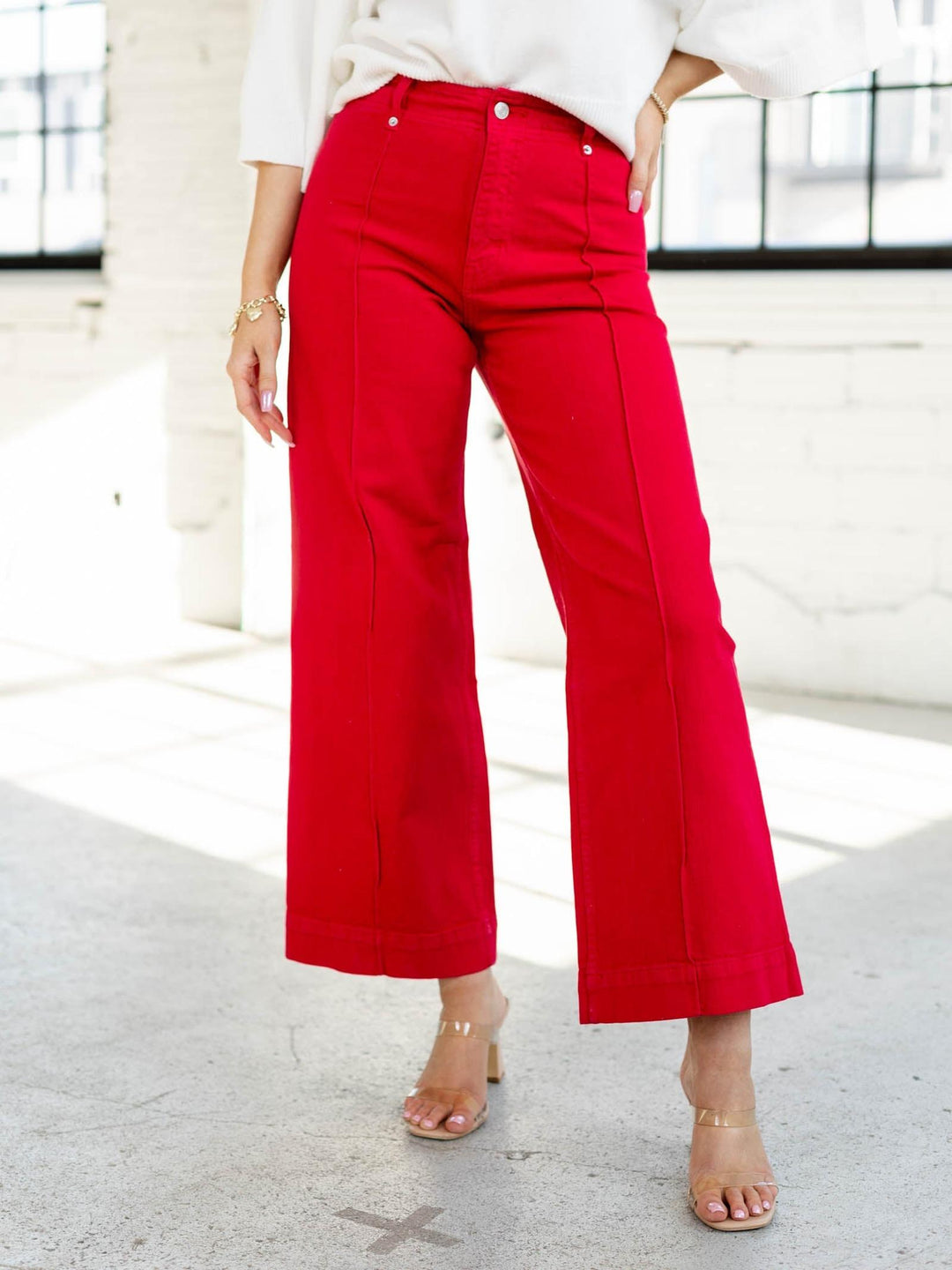 Person wearing red pants and a white top in an indoor setting