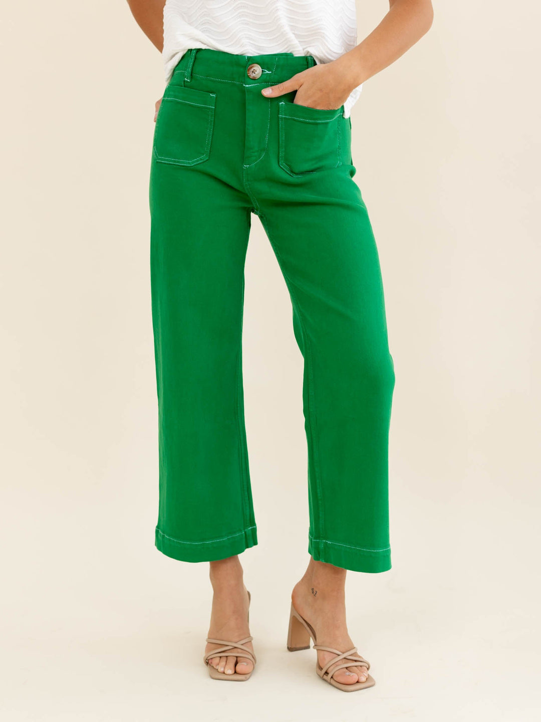 Green pants worn by a person on a beige background