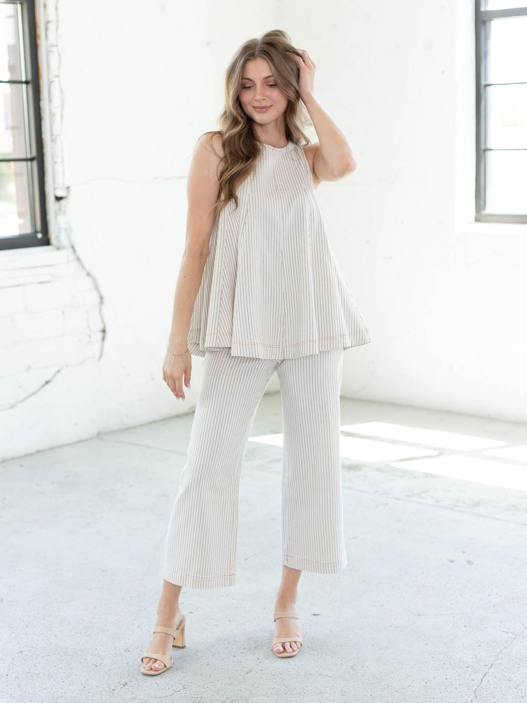 Model wears a mineral-washed swing top with blue pinstripes, crew neck, and hook button closure.