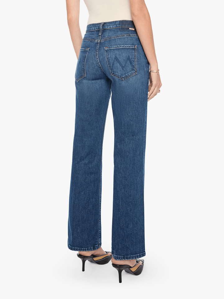 A model shown from the back wearing blue high-waisted straight-leg jeans, a white top, and black high-heeled sandals against a plain white background.
