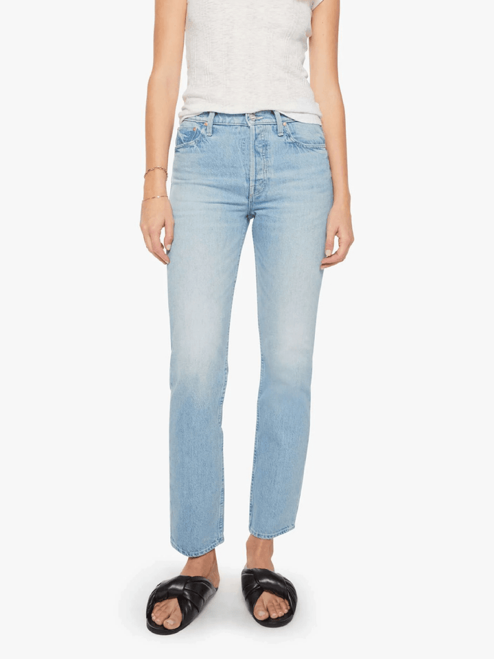 A model wearing light-wash blue straight-leg jeans, a light gray sleeveless top, and black slide sandals, shown from the waist down against a plain white background.