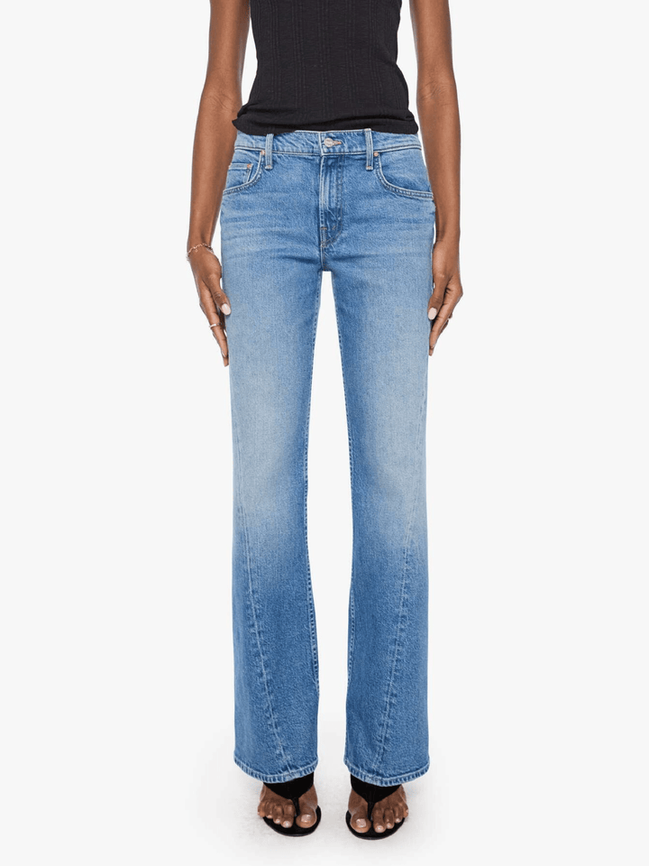 A model wearing a pair of light blue high-rise flare jeans with a faded wash, styled with a black top and black sandals against a plain white background.