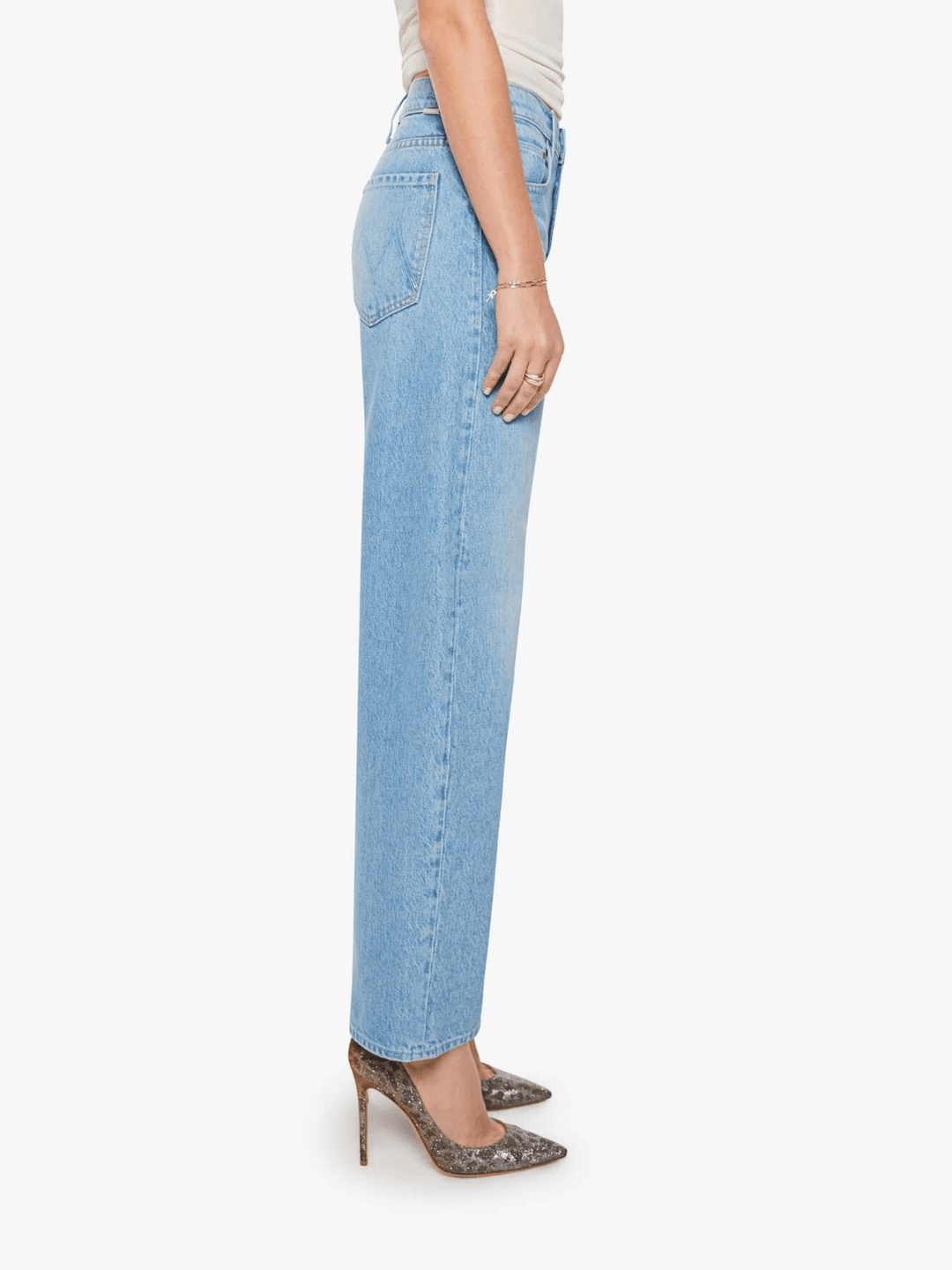 A side profile view of a model wearing light-wash blue straight-leg jeans, styled with brown snakeskin-patterned high heels against a plain white background.