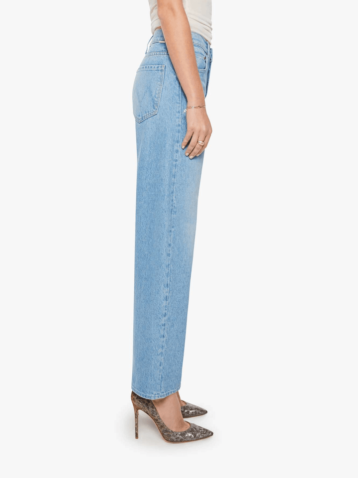 A side profile view of a model wearing light-wash blue straight-leg jeans, styled with brown snakeskin-patterned high heels against a plain white background.
