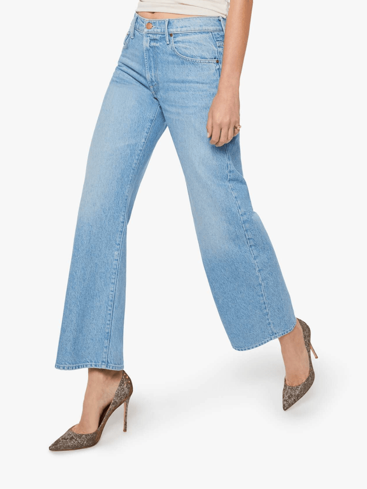 A model wearing light blue wide-leg cropped jeans with a faded wash, styled with brown leopard-print pointed-toe heels against a plain white background.
