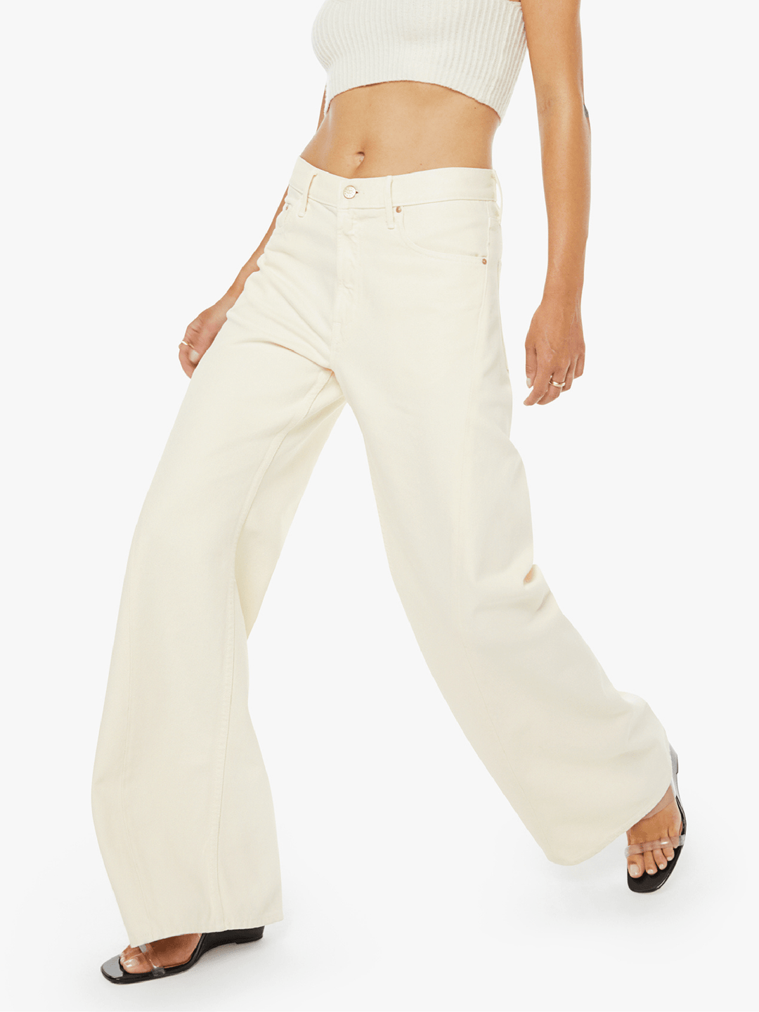 Person wearing cream-colored flared pants on a white background