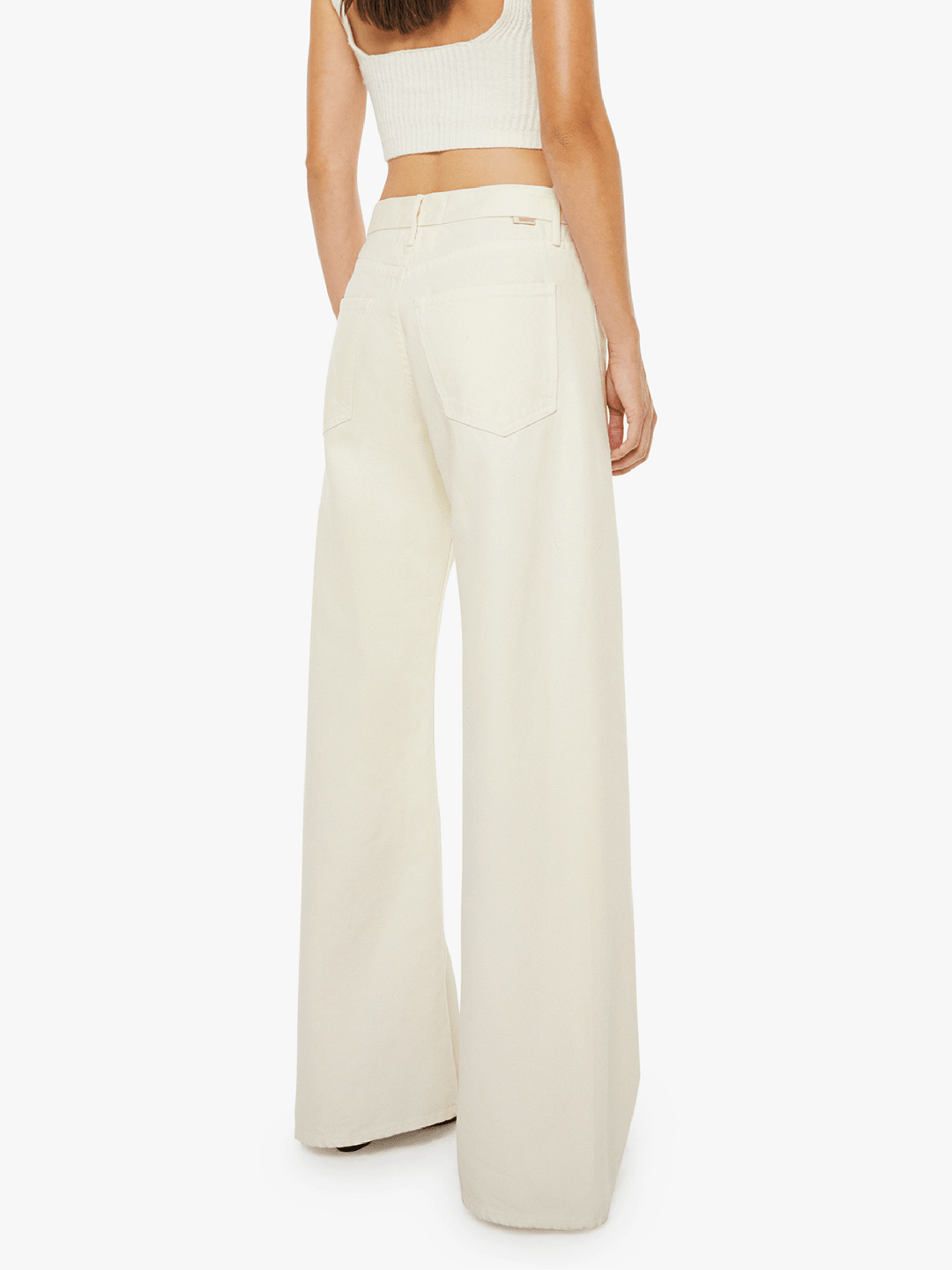 Person wearing a white top and wide-leg pants on a white background