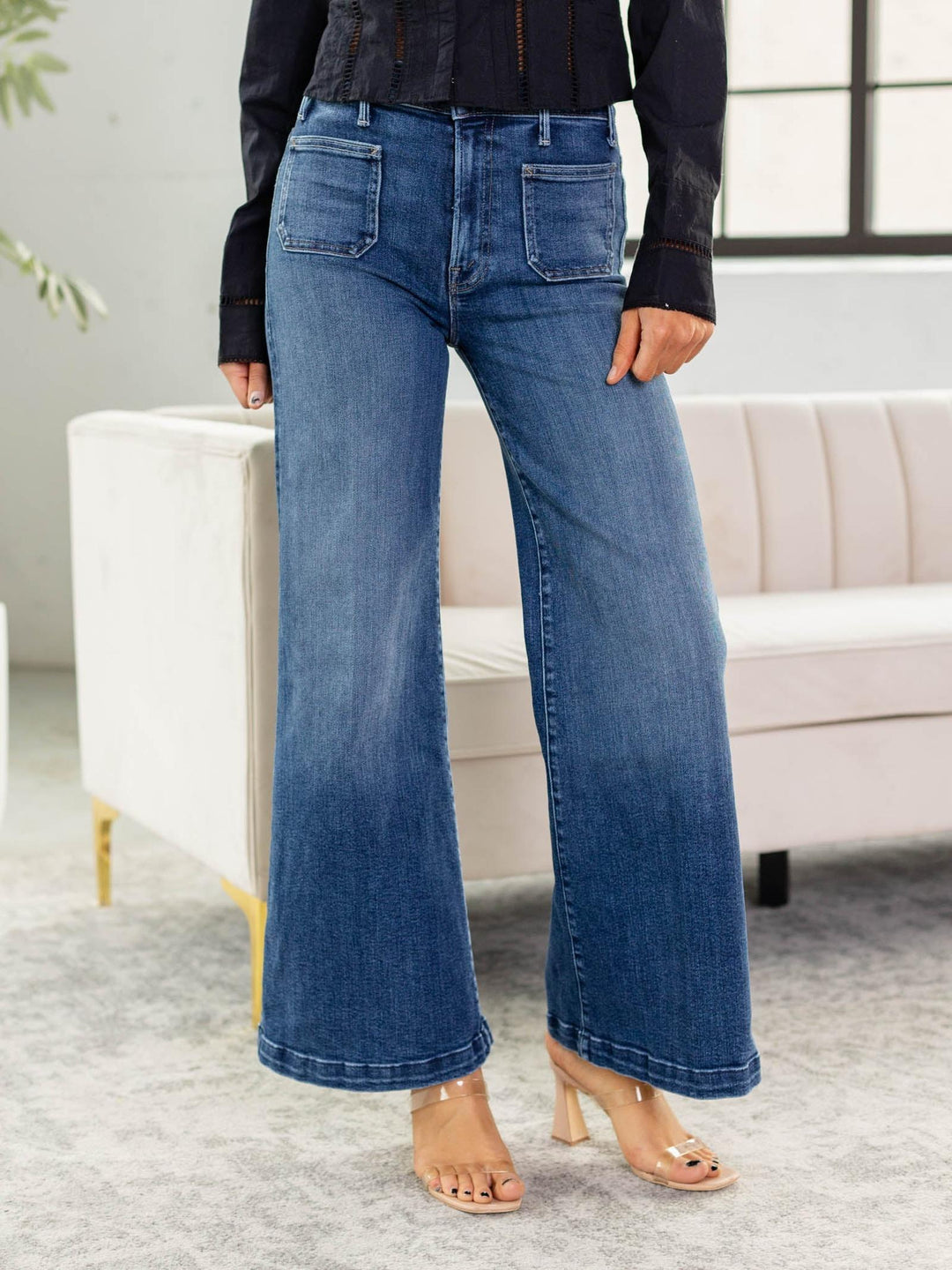 Person wearing blue wide-leg jeans in a living room setting