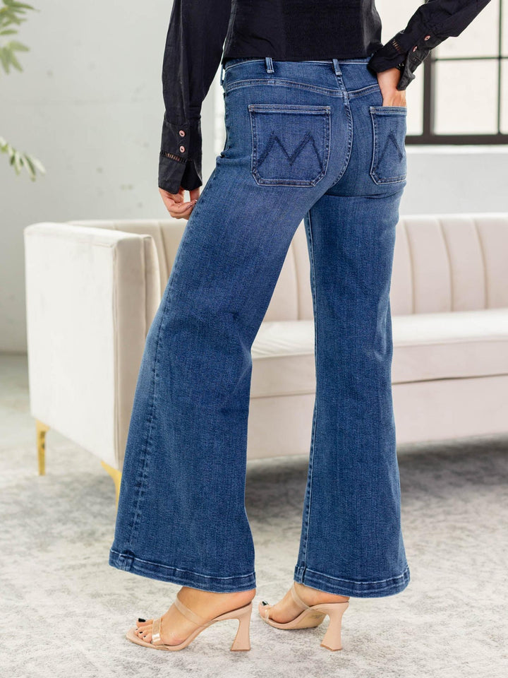 Person wearing blue flared jeans in a living room setting
