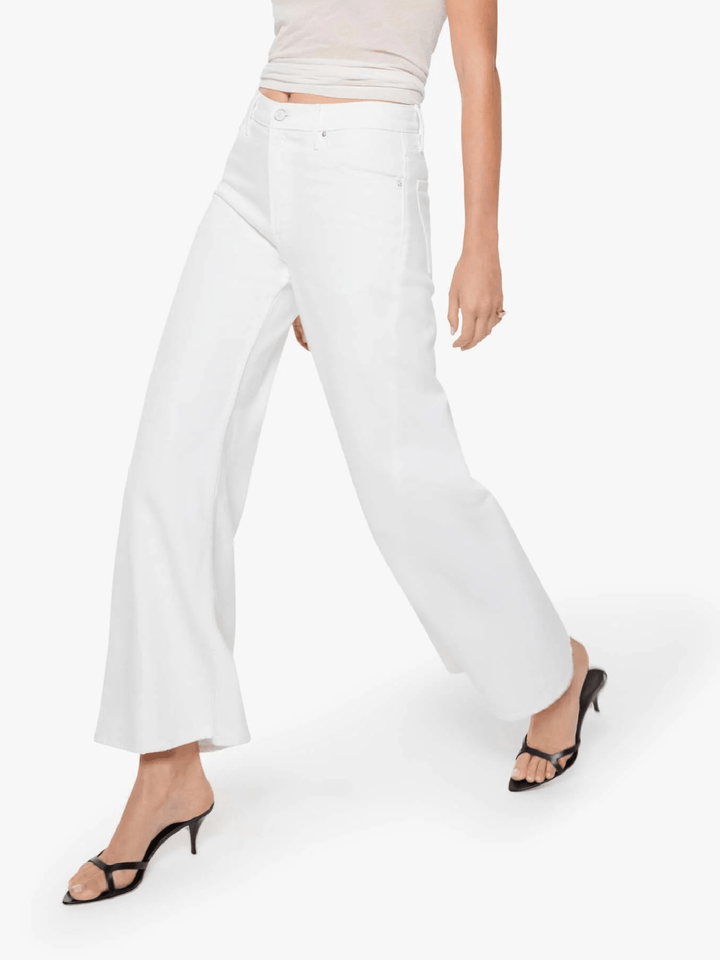 White wide-leg cropped pants shown on a model from the waist down, paired with black strappy mule heels against a clean white studio background.